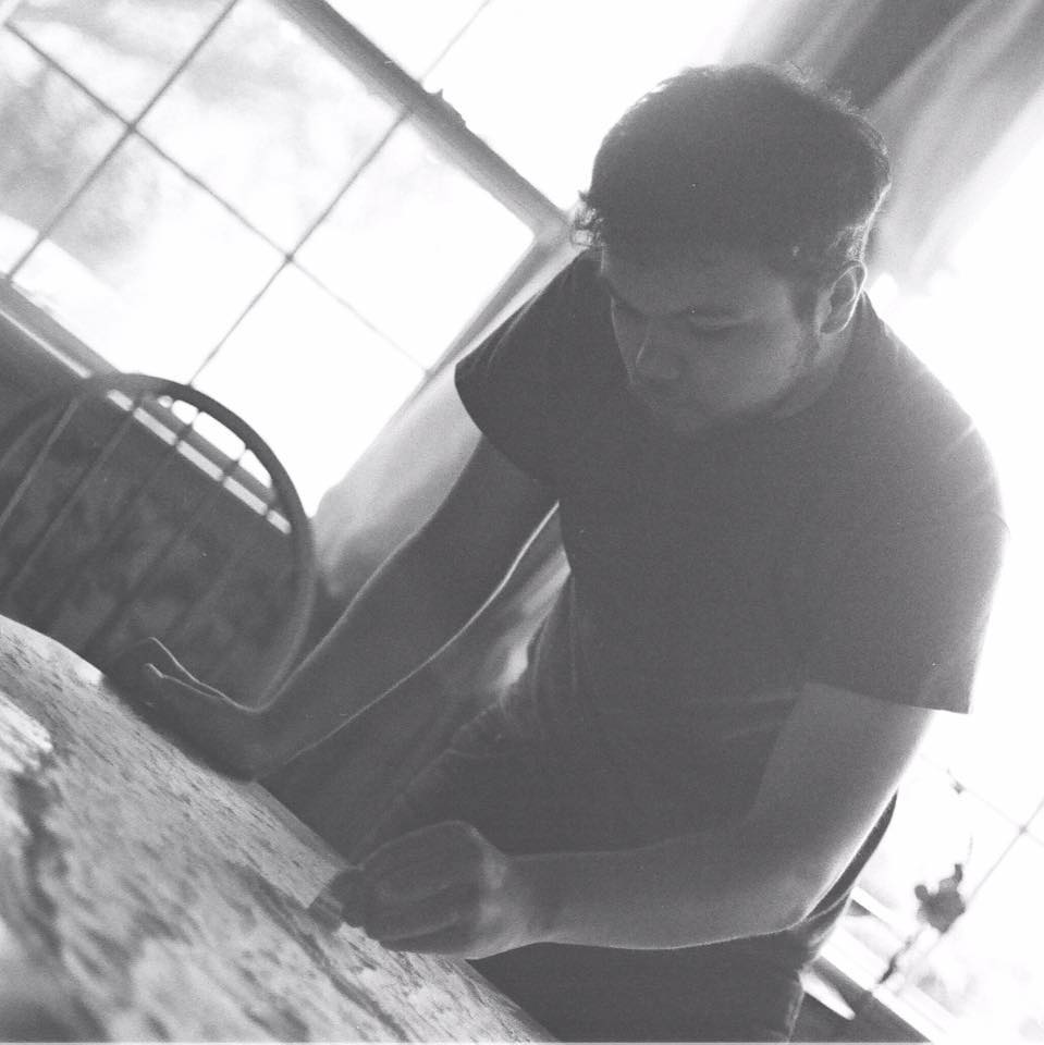 A man standing in front of a table with papers.