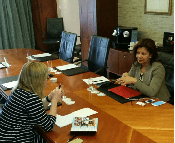 Two women sitting at a table in front of each other.