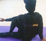 project yogi stretching A person sitting on the ground in a yoga pose.