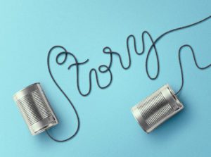 Two tin cans connected to a wire with the word " story " written on them.