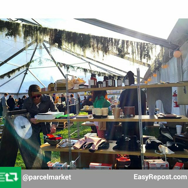 A tent with people looking at items on display.