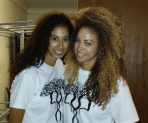 Two women with long hair and a tree shirt