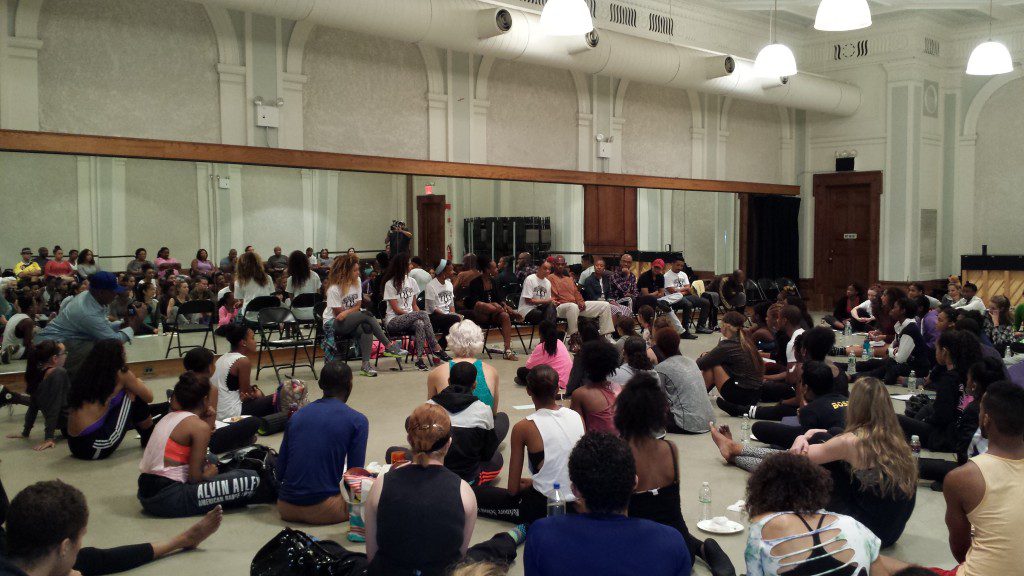 A group of people sitting in the middle of a room.