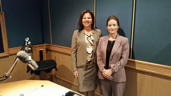 Two women in suits standing next to each other.