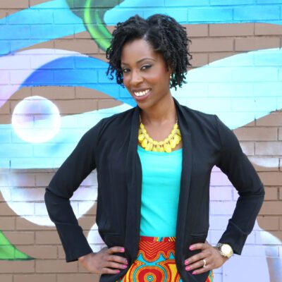 A woman standing in front of a mural.