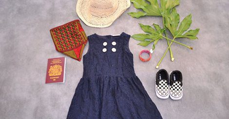 A blue dress and shoes are laid out on the floor.